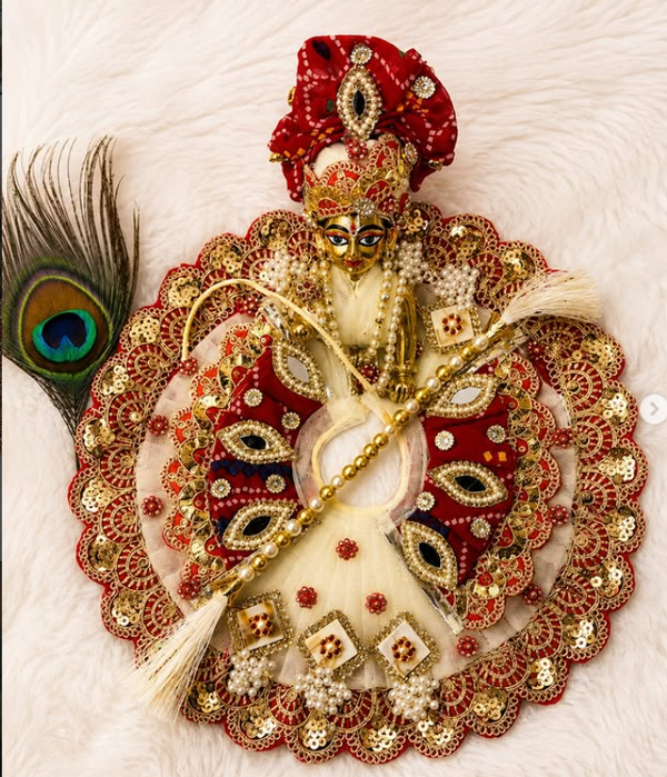 Red and white Laddu Gopal poshak with intricate embroidery and peacock feather